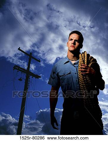 Low angle view of a young man carrying a rope on his shoulders View Large Photo Image Stock Photograph - Low angle view of a young man carrying a rope on his shoulders. Fotosearch