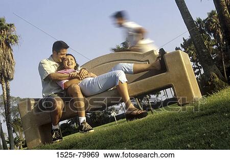 Low angle view of a young man embracing a young woman in a park View Large Photo Image Stock Photo - Low angle view of a young man embracing a young woman in a park. Fotosearch