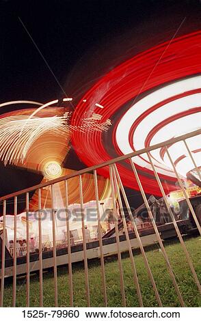 Low angle view of amusement park rides lit up at night View Large Photo Image Stock Image - Low angle view of amusement park rides lit up at night. Fotosearch