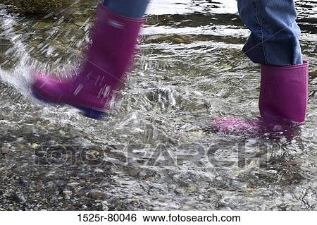 Low section view of a person splashing water with galoshes View Large Photo Image Stock Photograph - Low section view of a person splashing water with galoshes. Fotosearch