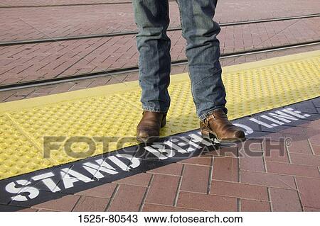 Low section view of a person standing on a platform View Large Photo Image Stock Image - Low section view of a person standing on a platform. Fotosearch