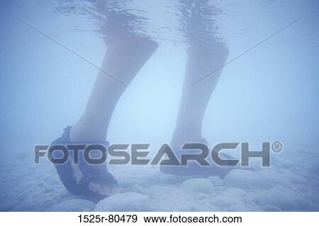 Low section view of a person standing in water View Large Photo Image Stock Photo - Low section view of a person standing in water. Fotosearch