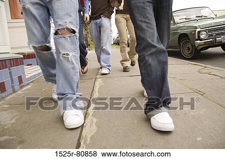 Stock Photo - Low section view of five people walking on a sidewalk. Fotosearch