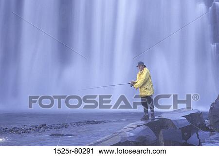 Mid adult man fly-fishing near a waterfall View Large Photo Image Stock Image - Mid adult man fly-fishing near a waterfall. Fotosearch