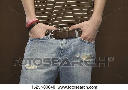 Stock Photo - Mid section view of a man standing with his hands in pockets. Fotosearch