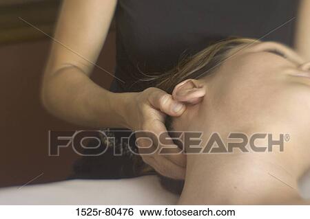 Stock Photograph - Mid section view of a woman massaging a young woman's head. Fotosearch