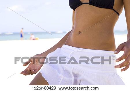 Mid section view of a woman standing on the beach View Large Photo Image Stock Photo - Mid section view of a woman standing on the beach. Fotosearch