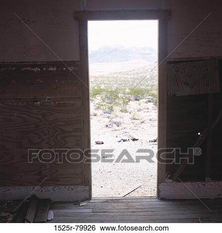 Stock Photograph - Mountains and shrubs seen through a door. Fotosearch
