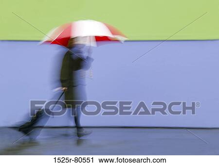 Person holding an umbrella and carrying luggage View Large Photo Image Stock Image - Person holding an umbrella and carrying luggage. Fotosearch
