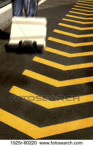Person walking near the Chevron Road sign View Large Photo Image Stock Image - Person walking near the Chevron Road sign. Fotosearch