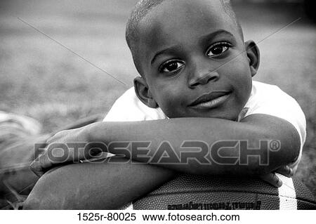 Portrait of a boy leaning on a football View Large Photo Image Stock Photography - Portrait of a boy leaning on a football. Fotosearch