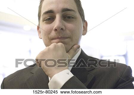 Stock Photography - Portrait of a businessman thinking with his hand on his chin. Fotosearch