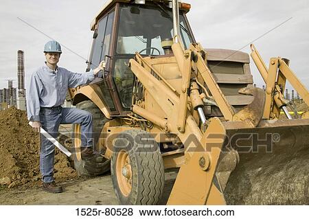 Portrait of a construction worker standing beside a bulldozer View Large Photo Image Stock Photo - Portrait of a construction worker standing beside a bulldozer. Fotosearch