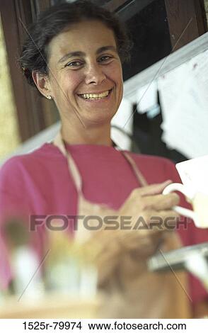 Portrait of a mid adult woman holding a cup and smiling View Large Photo Image Picture - Portrait of a mid adult woman holding a cup and smiling. Fotosearch