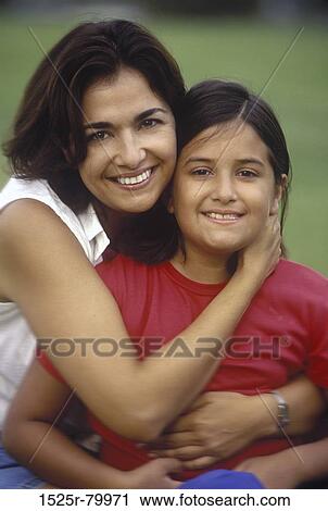 Portrait of a mid adult woman hugging her daughter View Large Photo Image Stock Image - Portrait of a mid adult woman hugging her daughter. Fotosearch