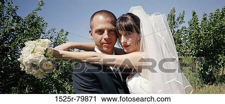 Portrait of a newlywed couple embracing each other View Large Photo Image Stock Image - Portrait of a newlywed couple embracing each other. Fotosearch