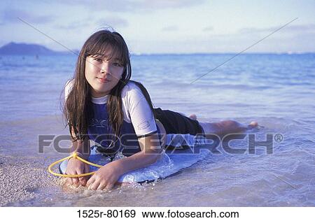 Portrait of a teenage girl lying on a bodyboard on the beach View Large Photo Image Stock Photo - Portrait of a teenage girl lying on a bodyboard on the beach. Fotosearch