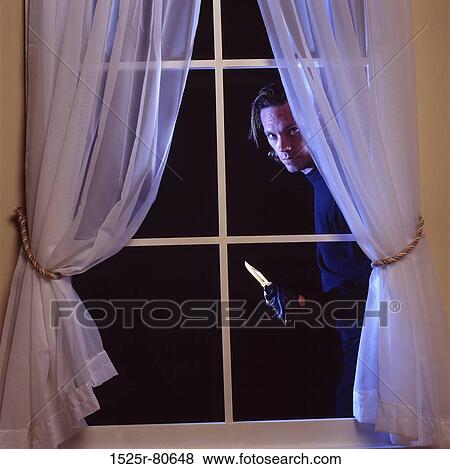 Portrait of a thief peeking through a window View Large Photo Image Stock Photo - Portrait of a thief peeking through a window. Fotosearch