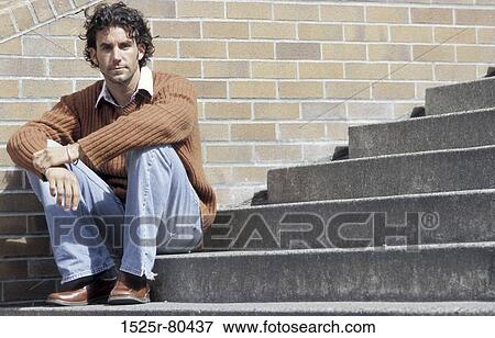 Portrait of a young man sitting on a staircase View Large Photo Image Stock Photo - Portrait of a young man sitting on a staircase. Fotosearch