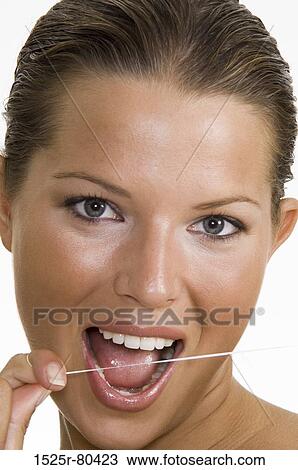 Portrait of a young woman flossing her teeth View Large Photo Image Stock Image - Portrait of a young woman flossing her teeth. Fotosearch