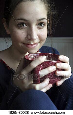 Portrait of a young woman holding a cup of coffee View Large Photo Image Stock Photo - Portrait of a young woman holding a cup of coffee. Fotosearch