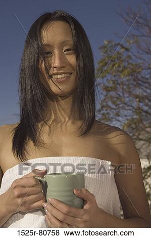 Portrait of a young woman holding a mug View Large Photo Image Stock Photo - Portrait of a young woman holding a mug. Fotosearch
