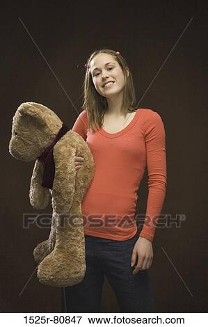 Portrait of a young woman holding a teddy bear View Large Photo Image Stock Photo - Portrait of a young woman holding a teddy bear. Fotosearch