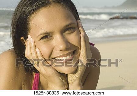Portrait of a young woman smiling on the beach View Large Photo Image Stock Photograph - Portrait of a young woman smiling on the beach. Fotosearch