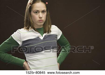 Portrait of a young woman standing with arms akimbo View Large Photo Image Stock Photography - Portrait of a young woman standing with arms akimbo. Fotosearch