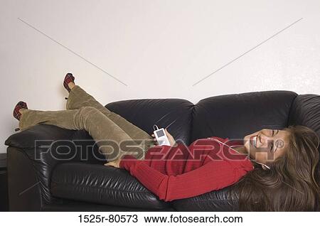 Portrait of a young woman wearing headphones and listening to music View Large Photo Image Stock Image - Portrait of a young woman wearing headphones and listening to music. Fotosearch
