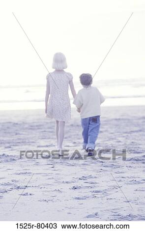 Rear view of a girl walking with her brother on the beach View Large Photo Image Stock Image - Rear view of a girl walking with her brother on the beach. Fotosearch