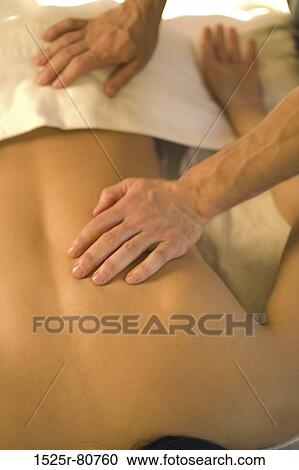 Rear view of a woman getting a back massage from a massage therapist View Large Photo Image Stock Image - Rear view of a woman getting a back massage from a massage therapist. Fotosearch