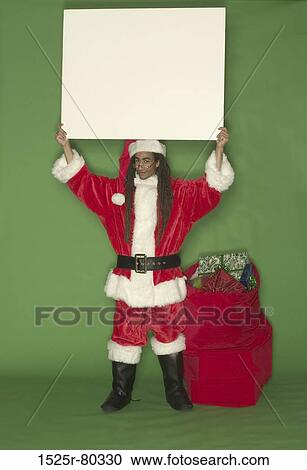 Stock Image - Santa Claus holding a placard. Fotosearch