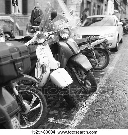 Scooters and cars parked in a parking lot View Large Photo Image Picture - Scooters and cars parked in a parking lot. Fotosearch