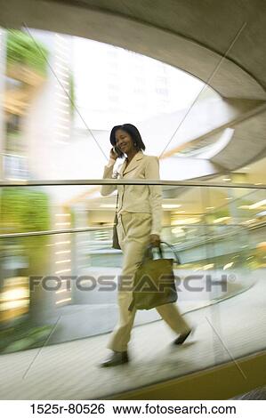 Side profile of a businesswoman talking on a mobile phone View Large Photo Image Stock Photograph - Side profile of a businesswoman talking on a mobile phone. Fotosearch