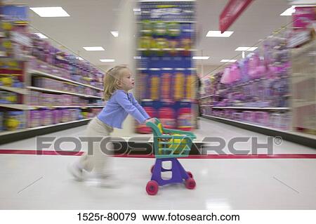 Side profile of a girl pushing a shopping cart in a supermarket View Large Photo Image Stock Photo - Side profile of a girl pushing a shopping cart in a supermarket. Fotosearch