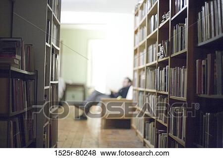 Side profile of a man sitting in a library View Large Photo Image Stock Photo - Side profile of a man sitting in a library. Fotosearch