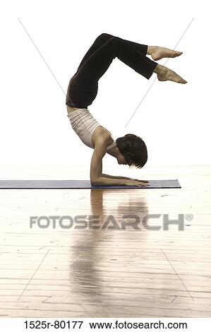 Stock Photo - Side profile of a woman doing handstand. Fotosearch