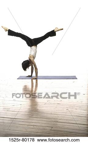 Side profile of a woman doing handstand View Large Photo Image Stock Photo - Side profile of a woman doing handstand. Fotosearch