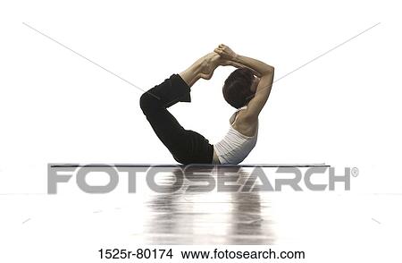 Picture - Side profile of a woman performing bow pose. Fotosearch