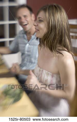 Side profile of a young couple sitting at a table View Large Photo Image Stock Image - Side profile of a young couple sitting at a table. Fotosearch