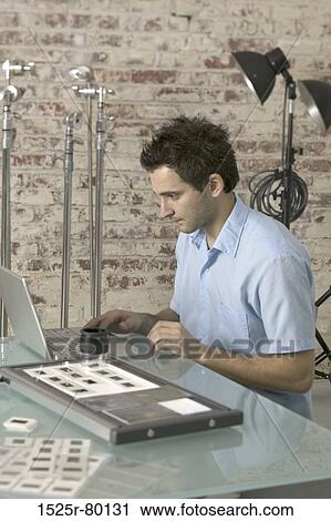 Side profile of a young man using a laptop View Large Photo Image Stock Image - Side profile of a young man using a laptop. Fotosearch