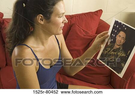 Side profile of a young woman looking at a photograph View Large Photo Image Stock Image - Side profile of a young woman looking at a photograph. Fotosearch