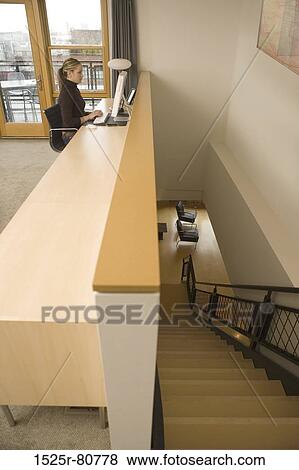 Side profile of a young woman using a computer beside a staircase View Large Photo Image Stock Photo - Side profile of a young woman using a computer beside a staircase. Fotosearch