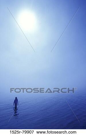 Silhouette of a person wading in the sea View Large Photo Image Stock Photo - Silhouette of a person wading in the sea. Fotosearch