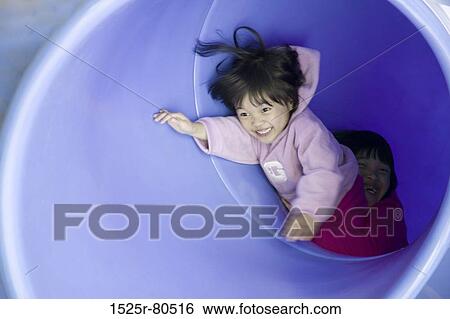 Two girls playing in a pipe View Large Photo Image Stock Photograph - Two girls playing in a pipe. Fotosearch