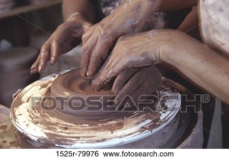 Two pairs of hands shaping clay on a potter's wheel View Large Photo Image Stock Photograph - Two pairs of hands shaping clay on a potter's wheel. Fotosearch