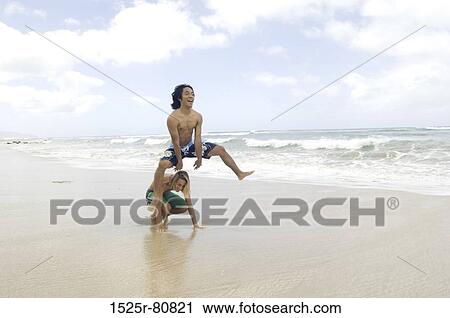 Two young men playing leapfrog on the beach View Large Photo Image Stock Image - Two young men playing leapfrog on the beach. Fotosearch