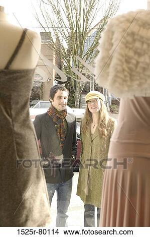 Young couple looking at mannequins in a window display View Large Photo Image Picture - Young couple looking at mannequins in a window display. Fotosearch
