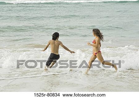Young couple running in water View Large Photo Image Picture - Young couple running in water. Fotosearch